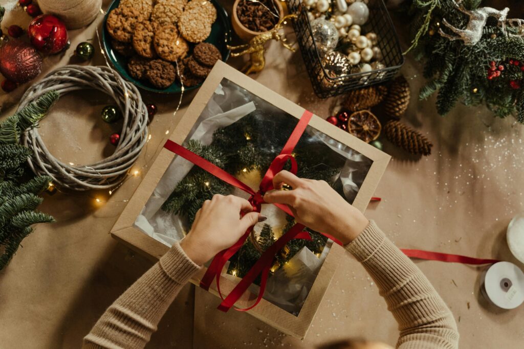 pexels photo 6063706 6063706 Top view of a Christmas gift wrapping scene with cookies, baubles, and festive decorations.